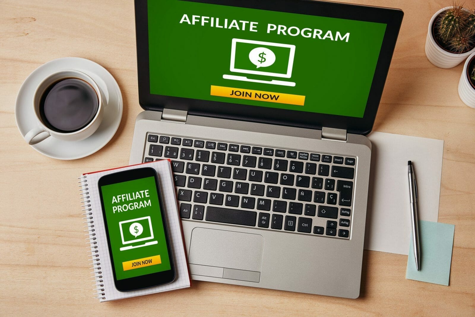 Affiliate program concept on laptop and smartphone screen over wooden table. All screen content is designed by me. Flat lay
